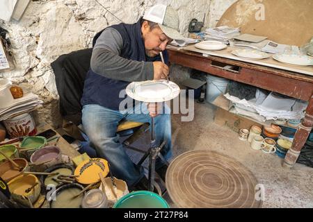 A Mexican craftsman hand paints ceramic plates at Gorky Gonzales pottery workshop in Guanajuato, Mexico. The workshop rescued traditional majolica pottery which had become lost to time. Stock Photo