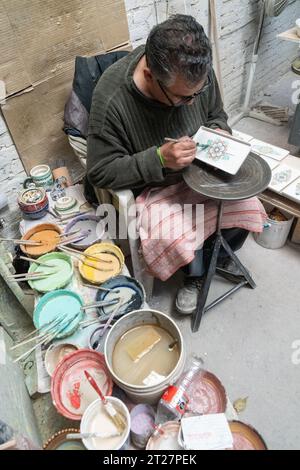 A Mexican craftsman hand paints ceramic plates at Gorky Gonzales pottery workshop in Guanajuato, Mexico. The workshop rescued traditional majolica pottery which had become lost to time. Stock Photo