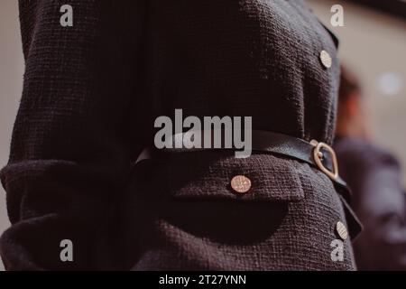 Classy black jacket, leather belt and golden buttons. Fashion details, female outfit Stock Photo