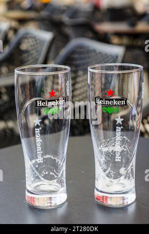 Two empty Heineken badged beer glasses on a table top in a cafe bar in Bordeaux, a port city on the Garonne River in southwestern France Stock Photo