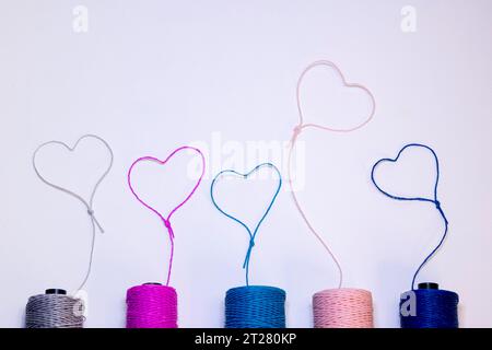 Conceptual art made with threads that form hearts on a light background. Stock Photo