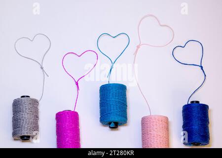 Conceptual art made with threads that form hearts on a light background. Stock Photo