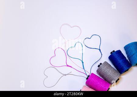 Conceptual art made with threads that form hearts on a light background. Stock Photo