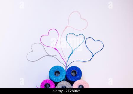 Conceptual art made with threads that form hearts on a light background. Stock Photo