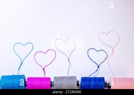 Conceptual art made with threads that form hearts on a light background. Stock Photo