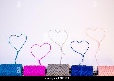 Conceptual art made with threads that form hearts on a light background. Stock Photo