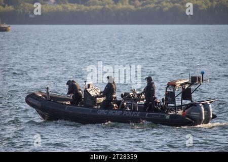 A group of police officers on a RCMP boat patrol the shoreline of a body of water Stock Photo