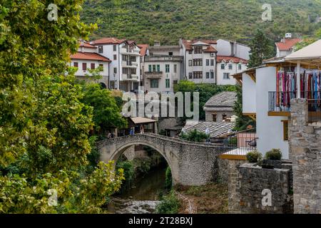 View of the Kriva Cuprija (Crooked Bridge) over the Radobolja River, a small and old stone bridge in Mostar, Bosnia and Herzegovina, built in 1558 by Stock Photo