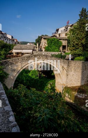 The Kriva Cuprija (Crooked Bridge) over the Radobolja River, a small and old stone bridge in Mostar, Bosnia and Herzegovina, built in 1558 by the Otto Stock Photo
