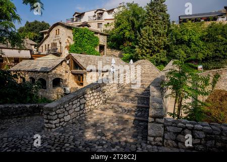 The Kriva Cuprija (Crooked Bridge) over the Radobolja River, a small and old stone bridge in Mostar, Bosnia and Herzegovina, built in 1558 by the Otto Stock Photo