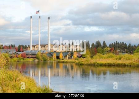 Bend, OR, USA - October 11, 2023; Historic three smokestacks in the Old Mill District of Bend Oregon above the Descutes River Stock Photo