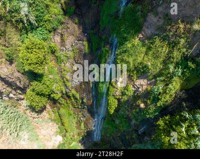 Aerial drone view of Angels waterfall (Cascata dos Anjos) in Madeira island. The waterfall cascades over the rockface onto the regional roadway, and s Stock Photo