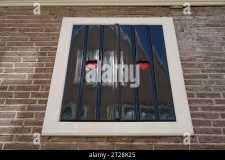 Typical traditional Dutch old fashioned closed wooden shutters with heart shaped hole in Haarlem, Holland, The Netherlands Stock Photo