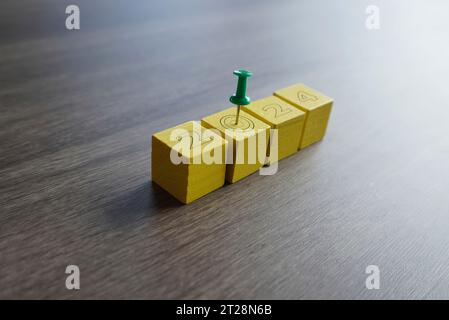 Close-up of a green pin on top of yellow blocks with number 2024. New Year's resolutions and goals concept Stock Photo