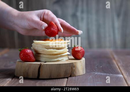 Stack of freshly prepared traditional pancakes with strawberries. Stock Photo