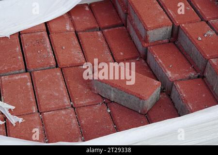 Stack of red concrete pavers in raffia bag outdoor Stock Photo