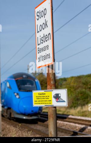 Caution, Look both ways and Stop Look Listern warning signs at level crossing on the East Coast Mainline railway. Stock Photo