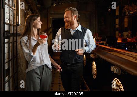 Man and young woman having friendly talk while rest in bar Stock Photo