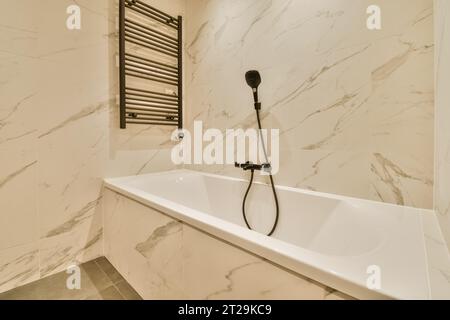 https://l450v.alamy.com/450v/2t29kc9/interior-of-modern-bathroom-with-marble-walls-and-black-shower-head-mounted-on-next-to-ceramic-bathtub-at-home-2t29kc9.jpg