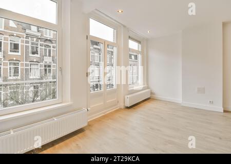 Interior of empty living room with large windows and hardwood floor in light apartment with white walls Stock Photo