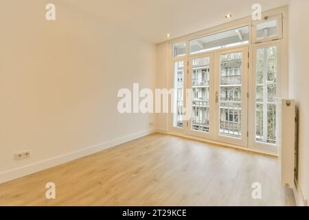 Unfurnished room with hardwood floors and white walls and window with large sliding doors in new house Stock Photo
