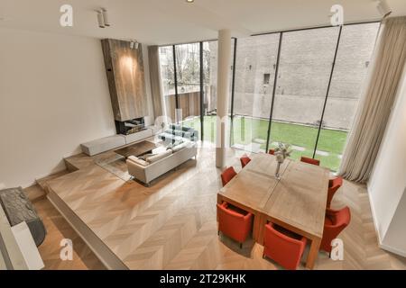 High angle view of contemporary house with open living room and dining room by large windows Stock Photo