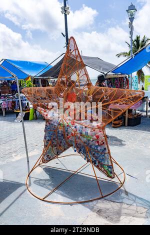 A metal bin in the shape of a starfish for recycling plastic water bottles in the open market in San Pedro, Ambergris Caye, Belize. Stock Photo