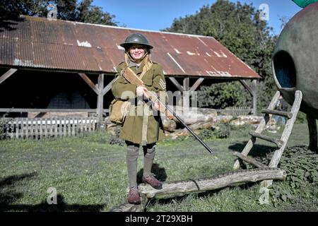 Young girl dressed in world war 2  British army uniform and carrying a rifle  at a 1940s WW2 reenactment, Avoncroft Museum Bromsgrove, England UK Stock Photo