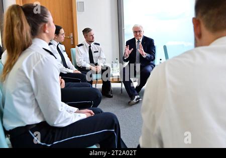 Meiningen, Germany. 18th Oct, 2023. Federal President Frank-Walter Steinmeier (back r) talks to police trainees at the Social Competence Center of the Thuringian Police Training Center. Steinmeier has moved his official residence to Meiningen for three days as part of 'Local Time Germany.' The stops outside Berlin are designed to talk to citizens about current challenges, wishes and concerns. Credit: Martin Schutt/dpa/Alamy Live News Stock Photo