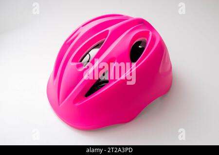 Pink children's protective helmet on a white background, close-up. Damage Stock Photo