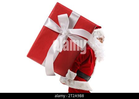 Profile shot of santa claus carrying a big preset on his back isolated on white background Stock Photo