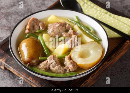 Swedish Lamb stew with fresh pears, potatoes, green beans close-up in a bowl on a wooden board. horizontal Stock Photo