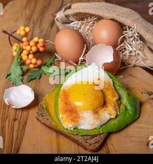 Fried egg covered in turmeric powder on a slice of toasted bread Stock Photo