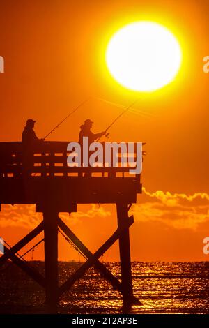 Isle Of Palms, United States. 17 October, 2023. Fisherman silhouetted by the sunrise try their luck from the Isle of Palms Pier, October 17, 2023 in Isle of Palms, South Carolina.  Credit: Richard Ellis/Richard Ellis/Alamy Live News Stock Photo