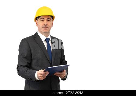 A man in a helmet holds a folder with a white sheet in his hands. A man in a suit is holding a folder over isolated background Stock Photo