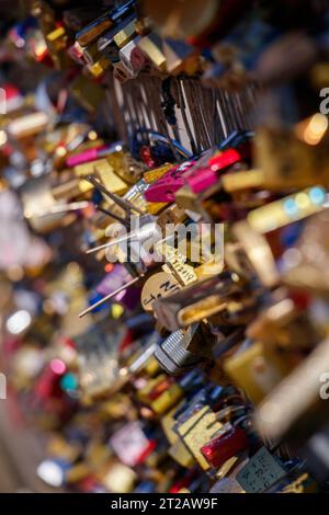 Engraved and marked padlocks hanging in the Pot Des Arts or Inlove ones bridge, hundreds of locks telling a lot of love stories, couples and families Stock Photo