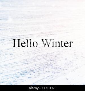 Hello winter text over tyre tracks in snow covered ground Stock Photo