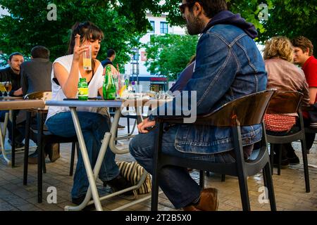 A young couple sitting and talking at an outdoor cafe in Lyon, France. Stock Photo