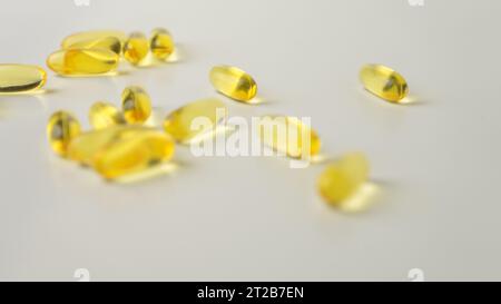 Omega-3-rich wild salmon and fish oil capsules presented on a soft off-white background. Stock Photo