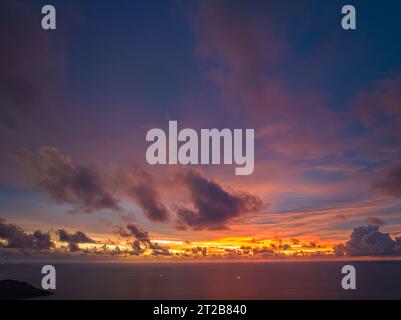Aerial view amazing yellow Light through the sky above Kata beach. Beautiful sunset are accompanied by soft clouds floating in stunning sky. wonderful Stock Photo