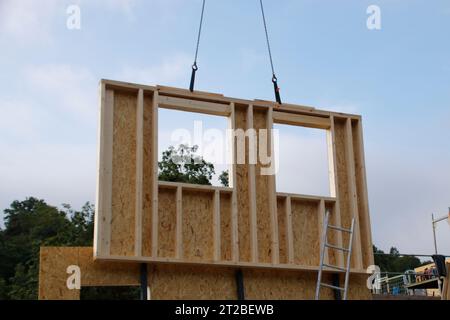 Wall with window of a prefabricated house is built with a crane Stock Photo