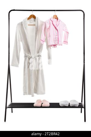 Rack with pajamas, bathrobe and slippers on white background Stock Photo
