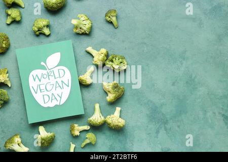 Card with text WORLD VEGAN DAY and fresh broccoli on green background Stock Photo