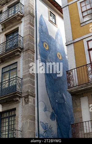 Vibrant mural of a large blue cat on the side of a building in Porto, Portugal Stock Photo