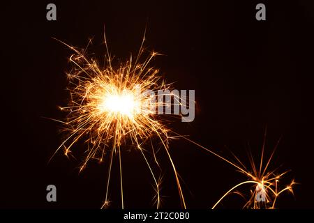 photo in this photography, a bright sparkler glows illuminating the New Year's holiday spirit. The close-up reveals the fiery beauty of a burning spar Stock Photo