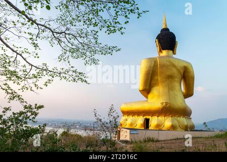 Beautiful, vibrant gold image of the Lao hilltop Buddha,a prominent landmark,reflecting light from the setting sun,popular holy site and tourist attra Stock Photo