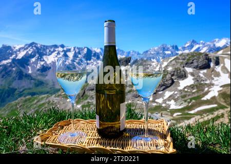 Glass and bottle of dry white Roussette de Savoie or Vin de Savoie wine from Savoy region served on Col du Galibier border Savoy region, France, view Stock Photo