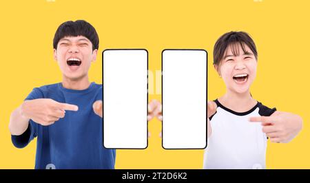 Excited Asian teenager student holding smartphone mockup of blank screen Stock Photo