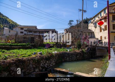 The small river in front of Fujian earthern buildings (also known as Hakka tulou) in mountains, Fujian, China Stock Photo