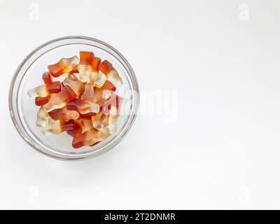 fruit gelatinous sweets. the bottle-shaped marmalade is in a small, round and transparent plate. making homemade sweets. baby treat, unusual shape of Stock Photo